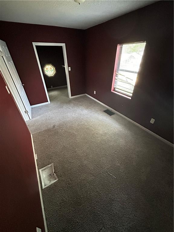 907 S Cedar Ave, Independence, MO 64052 - carpeted empty room featuring baseboards and a textured ceiling
