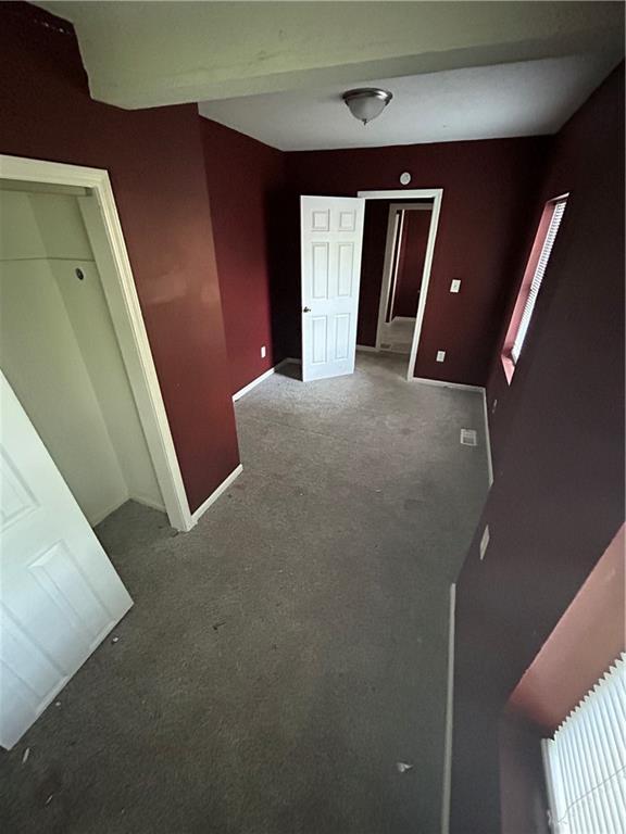 907 S Cedar Ave, Independence, MO 64052 - unfurnished bedroom with carpet and baseboards