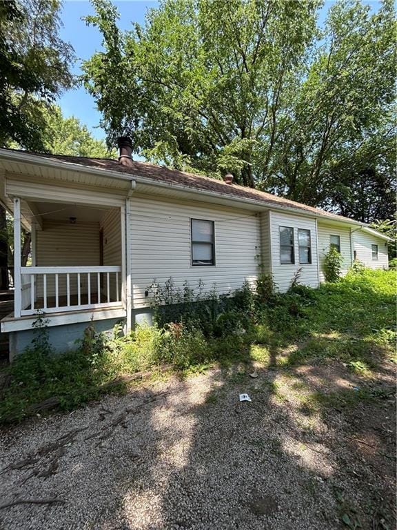 907 S Cedar Ave, Independence, MO 64052 - view of side of property with covered porch and a chimney