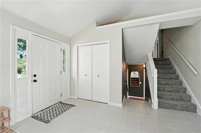 2903 E 107th Ter, Kansas City, MO 64137 - entryway featuring lofted ceiling, stairs, and tile patterned flooring