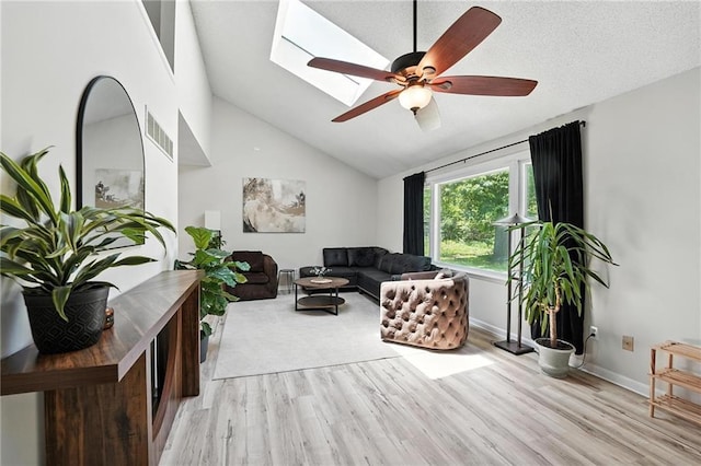 2903 E 107th Ter, Kansas City, MO 64137 - living room featuring light wood finished floors, a skylight, a ceiling fan, and lofted ceiling