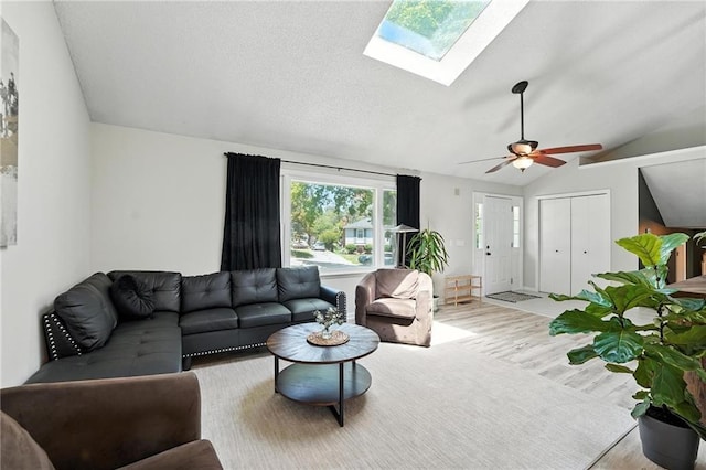2903 E 107th Ter, Kansas City, MO 64137 - living room with wood finished floors, lofted ceiling, a skylight, and a ceiling fan