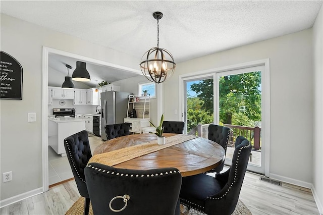 2903 E 107th Ter, Kansas City, MO 64137 - dining room featuring a chandelier and light wood-style floors