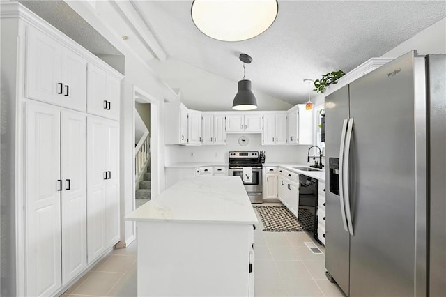 2903 E 107th Ter, Kansas City, MO 64137 - kitchen with appliances with stainless steel finishes, a center island, vaulted ceiling, a textured ceiling, and light tile patterned flooring