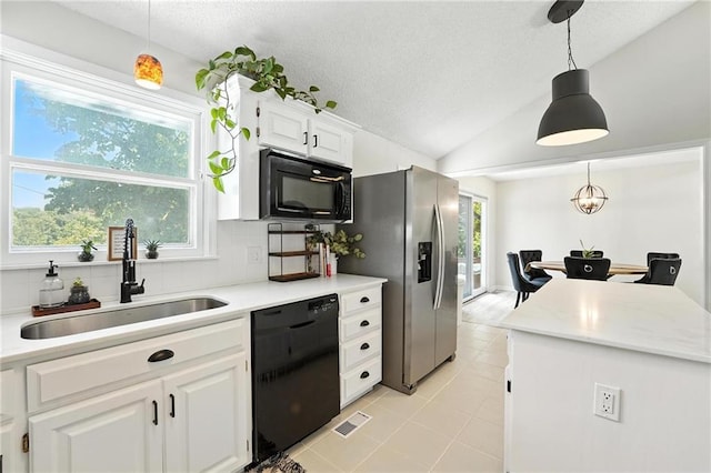 2903 E 107th Ter, Kansas City, MO 64137 - kitchen with black appliances, light countertops, plenty of natural light, white cabinets, and lofted ceiling