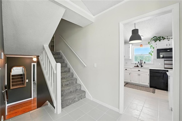 2903 E 107th Ter, Kansas City, MO 64137 - stairway with a textured ceiling, tile patterned floors, and ornamental molding