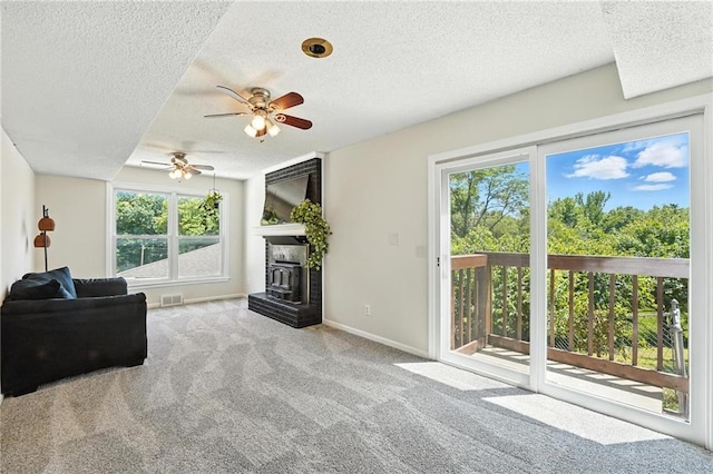 2903 E 107th Ter, Kansas City, MO 64137 - carpeted living room with a textured ceiling, healthy amount of natural light, and a ceiling fan