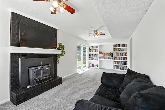 2903 E 107th Ter, Kansas City, MO 64137 - living room featuring ceiling fan, a fireplace, carpet flooring, a textured ceiling, and built in features