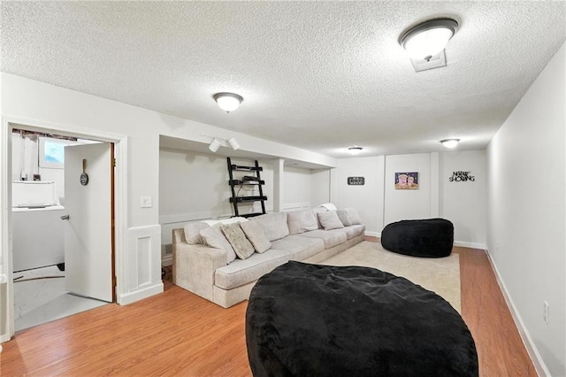 2903 E 107th Ter, Kansas City, MO 64137 - living room featuring light wood-style flooring and a textured ceiling