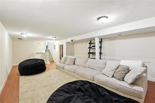 2903 E 107th Ter, Kansas City, MO 64137 - living room featuring a textured ceiling, stairway, and wood finished floors