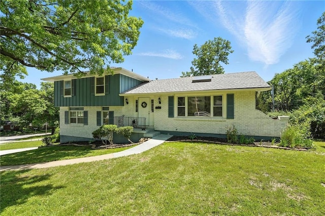 2903 E 107th Ter, Kansas City, MO 64137 - tri-level home with brick siding, a front lawn, and board and batten siding