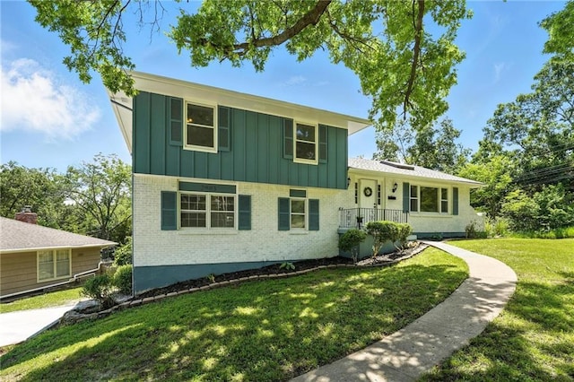 2903 E 107th Ter, Kansas City, MO 64137 - tri-level home with board and batten siding, brick siding, and a front yard