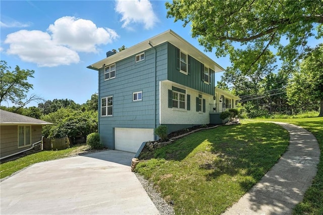 2903 E 107th Ter, Kansas City, MO 64137 - view of side of property with a yard, concrete driveway, a garage, and board and batten siding