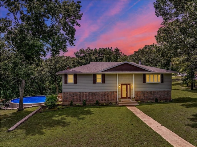 33383 Acorn Ln, Warsaw, MO 65355 - view of front of house with brick siding, a front lawn, and an outdoor pool