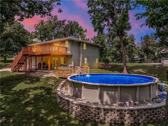 33383 Acorn Ln, Warsaw, MO 65355 - pool at dusk featuring a deck, a lawn, stairs, and an outdoor pool