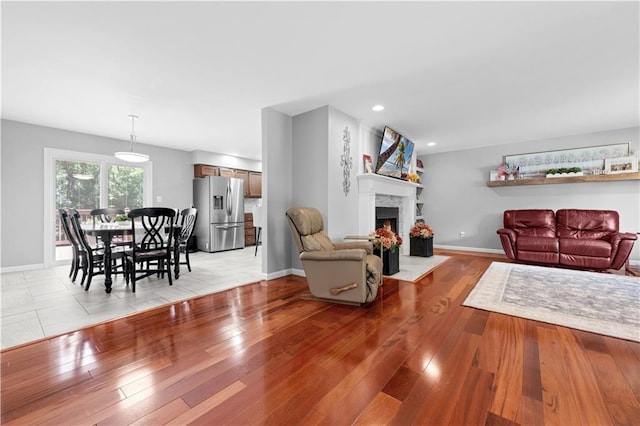 33383 Acorn Ln, Warsaw, MO 65355 - living room featuring a fireplace with flush hearth, light wood finished floors, and recessed lighting