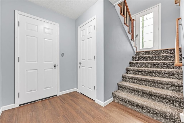 33383 Acorn Ln, Warsaw, MO 65355 - entryway with stairway, dark wood finished floors, and a textured ceiling