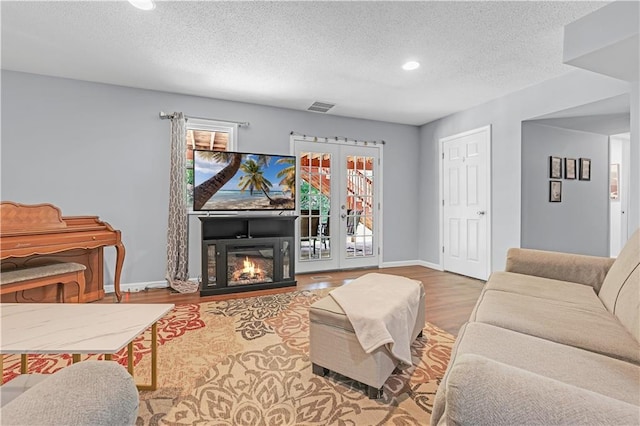 33383 Acorn Ln, Warsaw, MO 65355 - living area featuring a textured ceiling, wood finished floors, recessed lighting, and a glass covered fireplace
