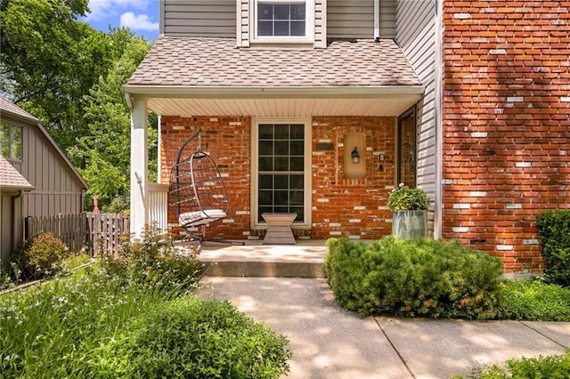11530 Hemlock St, Overland Park, KS 66210 - view of exterior entry featuring a porch, roof with shingles, and brick siding