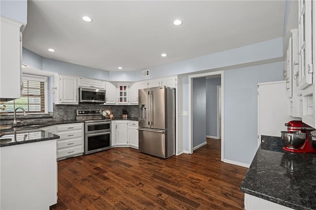 11530 Hemlock St, Overland Park, KS 66210 - kitchen with stainless steel appliances, dark wood-type flooring, backsplash, white cabinetry, and dark stone countertops