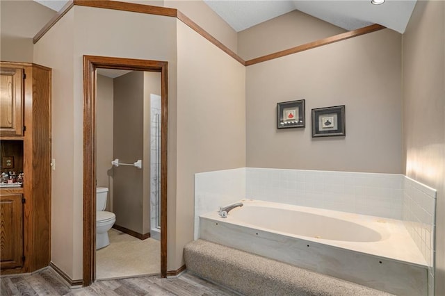 11530 Hemlock St, Overland Park, KS 66210 - full bath featuring wood finished floors, a garden tub, vaulted ceiling, and vanity