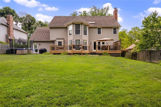 11530 Hemlock St, Overland Park, KS 66210 - rear view of house with a trampoline, a deck, and a chimney
