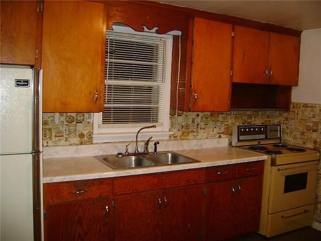 482 Fieldcrest Dr, Pittsburg, KS 66762 - kitchen with freestanding refrigerator, white range with electric stovetop, light countertops, and decorative backsplash