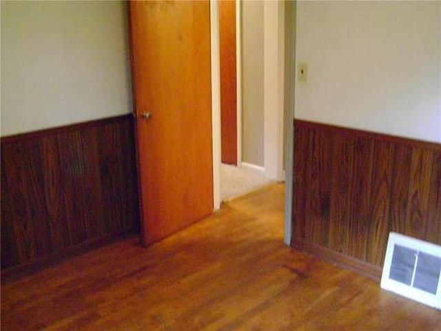 482 Fieldcrest Dr, Pittsburg, KS 66762 - unfurnished room featuring wood finished floors, wooden walls, and a wainscoted wall