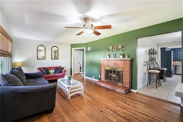 2110 N 70th Ter, Kansas City, KS 66109 - living room featuring a fireplace, a ceiling fan, and wood finished floors