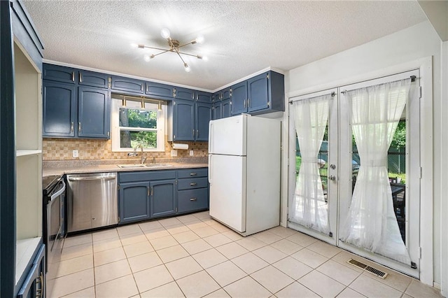 2110 N 70th Ter, Kansas City, KS 66109 - kitchen with stainless steel appliances, light countertops, backsplash, a textured ceiling, and a chandelier