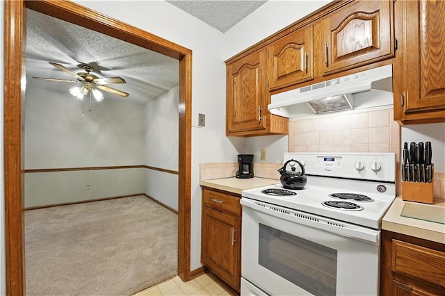 8001 Westridge Rd Unit 103, Raytown, MO 64138 - kitchen with white range with electric cooktop, under cabinet range hood, a textured ceiling, brown cabinets, and ceiling fan