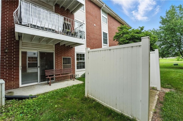 8001 Westridge Rd Unit 103, Raytown, MO 64138 - view of side of home with a balcony, brick siding, and a yard