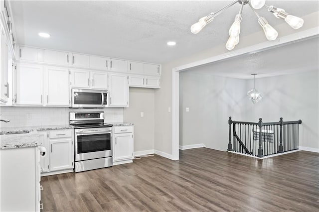 16722 E 35th Ter, Independence, MO 64055 - kitchen with appliances with stainless steel finishes, white cabinetry, dark wood-style flooring, backsplash, and a textured ceiling