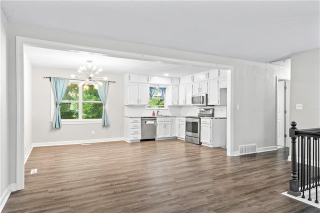16722 E 35th Ter, Independence, MO 64055 - kitchen with appliances with stainless steel finishes, a chandelier, white cabinetry, dark wood-style floors, and light countertops