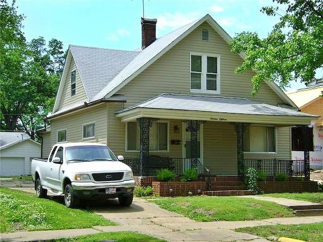 1918 S Elm St, Pittsburg, KS 66762 - view of front of home with covered porch, a chimney, a garage, driveway, and a front yard