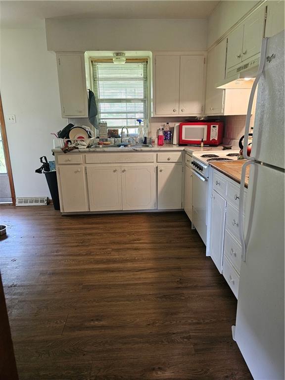 524 E Walnut St, Independence, MO 64050 - kitchen with white appliances, under cabinet range hood, plenty of natural light, and light countertops