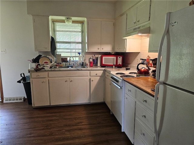 524 E Walnut St, Independence, MO 64050 - kitchen featuring white appliances, under cabinet range hood, dark wood-style flooring, and decorative backsplash