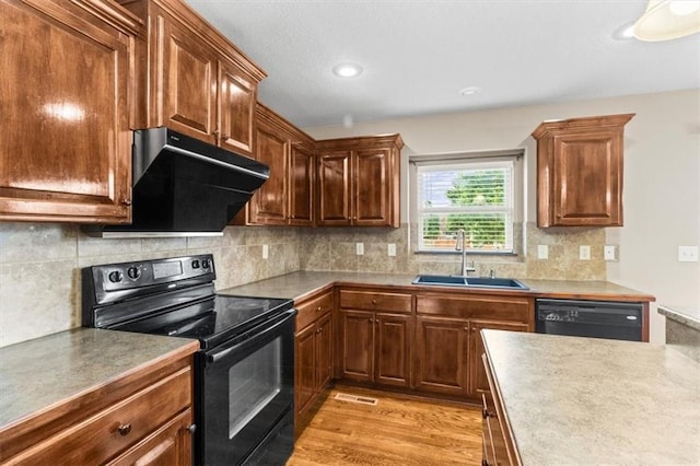 610 NW Green Dr, Grain Valley, MO 64029 - kitchen with black appliances, range hood, decorative backsplash, recessed lighting, and light wood-type flooring