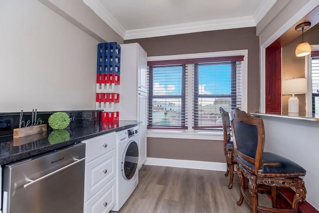 700 W 48th St Unit 301, Kansas City, MO 64112 - laundry room featuring washer / clothes dryer, ornamental molding, healthy amount of natural light, and light wood-type flooring