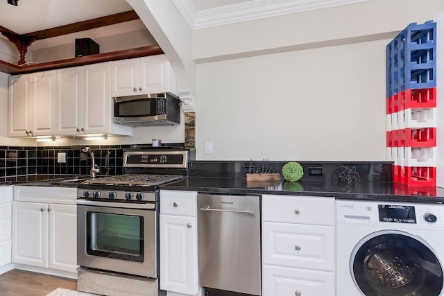 700 W 48th St Unit 301, Kansas City, MO 64112 - kitchen with washer / dryer, appliances with stainless steel finishes, ornamental molding, white cabinetry, and tasteful backsplash