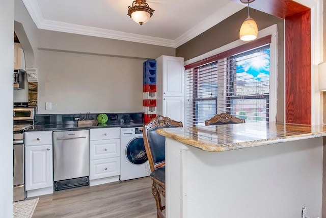 700 W 48th St Unit 301, Kansas City, MO 64112 - kitchen featuring washer / dryer, stainless steel appliances, white cabinetry, crown molding, and a peninsula