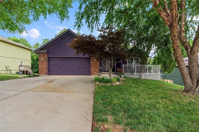 4116 NE 83rd St, Kansas City, MO 64119 - view of front of house featuring brick siding, a front lawn, concrete driveway, a garage, and a porch