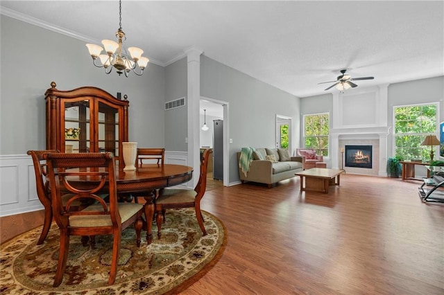 4116 NE 83rd St, Kansas City, MO 64119 - dining area with ceiling fan, wood finished floors, a chandelier, ornamental molding, and a tiled fireplace