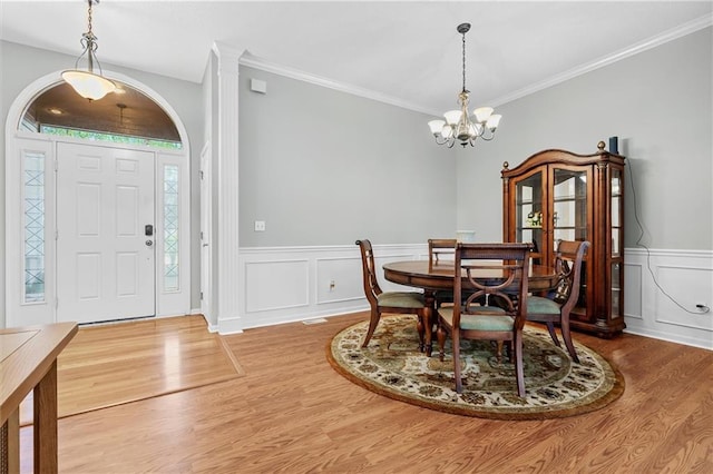 4116 NE 83rd St, Kansas City, MO 64119 - dining room featuring wood finished floors, a chandelier, a wainscoted wall, ornamental molding, and a decorative wall