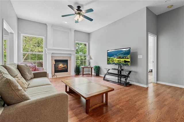 4116 NE 83rd St, Kansas City, MO 64119 - living area featuring a tile fireplace, ceiling fan, and wood finished floors