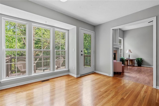 4116 NE 83rd St, Kansas City, MO 64119 - doorway with wood finished floors and a tile fireplace
