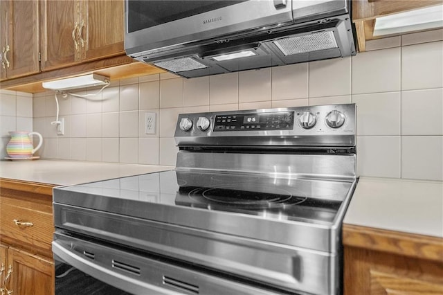 4116 NE 83rd St, Kansas City, MO 64119 - kitchen with stainless steel appliances, decorative backsplash, and light countertops