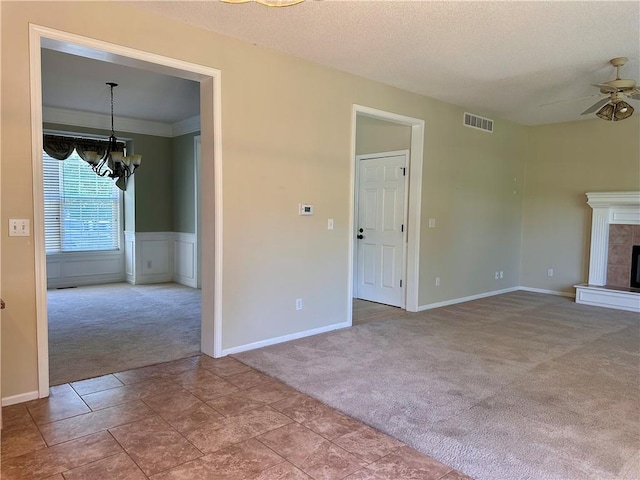 15598 S Blackfeather St, Olathe, KS 66062 - unfurnished living room with carpet flooring, a chandelier, ceiling fan, a tile fireplace, and wainscoting