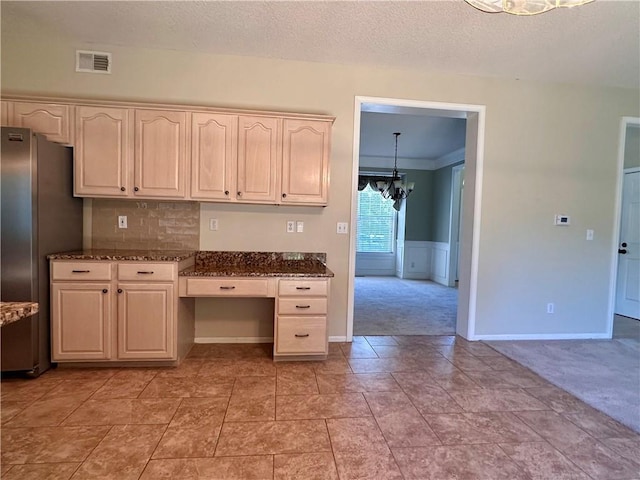 15598 S Blackfeather St, Olathe, KS 66062 - kitchen with a chandelier, freestanding refrigerator, light carpet, a textured ceiling, and dark stone counters