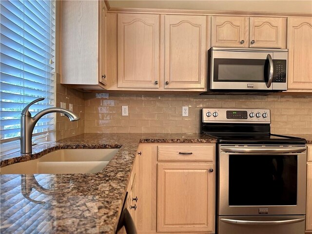 15598 S Blackfeather St, Olathe, KS 66062 - kitchen featuring stainless steel appliances, decorative backsplash, dark stone countertops, and light brown cabinets